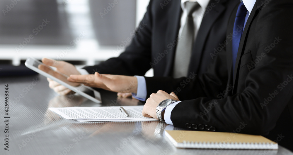 Wall mural unknown businessmen using tablet computer and work together at the glass desk in modern office, clos