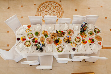 Served for a banquet table. Wine glasses with napkins, glasses and salads, top view