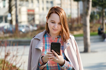 Young woman chatting on the phone outdoors in springtime