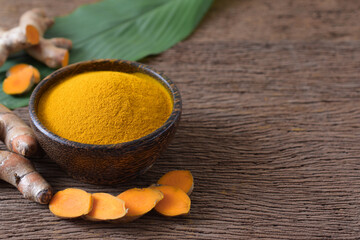  Turmeric powder and fresh turmeric (curcumin) on wooden background,herbal,copy space.