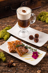 Irish coffee with grated dark chocolate on wooden table