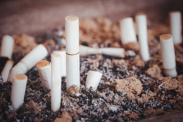 Many cigarette butts were left in an ashtray and filled with cigarette ash. Large number of smoking...