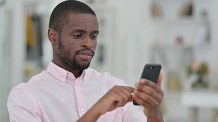 Obraz na płótnie Canvas Portrait of Serious African Man using Smartphone 