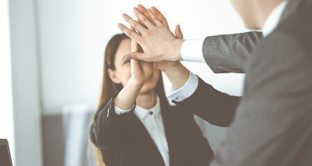 Obraz premium Unknown business people group joining hands in modern office. Businessmen and women making circle with their hands as a team, close-up