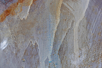 The metal surface painted with multicolored colors speckles and stripes is sloppy