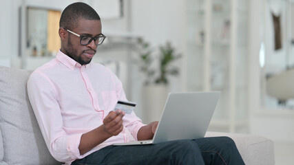 Online Payment on Laptop by African Man