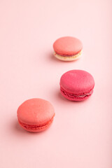 Magenta and pink macaroons on pink pastel background.  side view, close up.