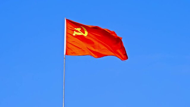 The flag of the Communist Party of China fluttering in the wind in the blue sky