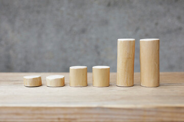 Thin and short barkless wooden log blocks on wooden table. Barkless cedar log set lined up individually in order of height on wooden background. 