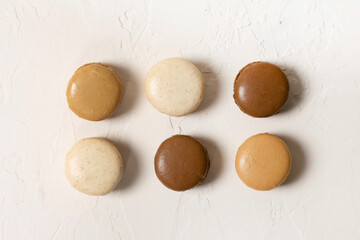 Vanilla, caramel and chocolate macaroons on white background