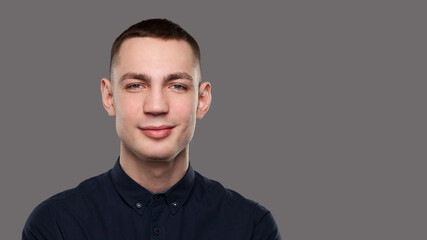 Young sincere man portrait isolated on gray background