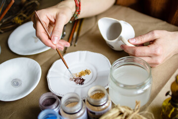 Hand-painting homemade ceramic dishes.