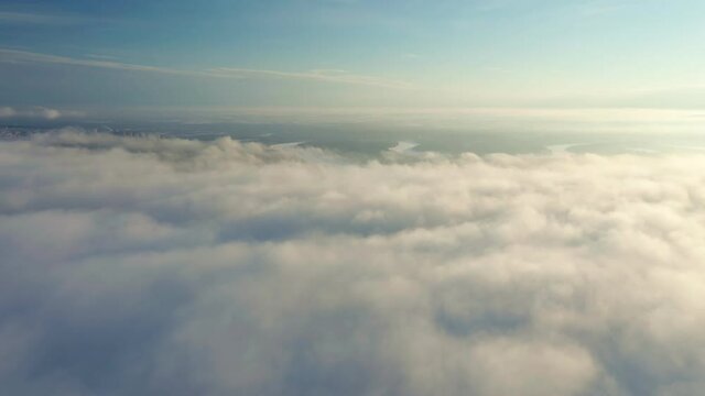 Cumulus clouds fill the sky with a dense layer. Footage shows a game of light and shadow at sunset. Green fields is below. High quality.
