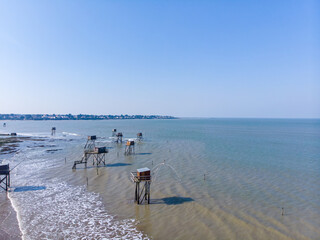 beautiful aerial shot of Fishing cabin over atlantic ocean. Fishing houses on stilts. French fishing huts called "Carrelets" on the french coast. Idyllic scene of Fishing carrelets in France