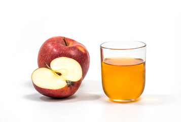 Close up of a glass of apple juice, with a whole and half apple. Natural apple juice on white background