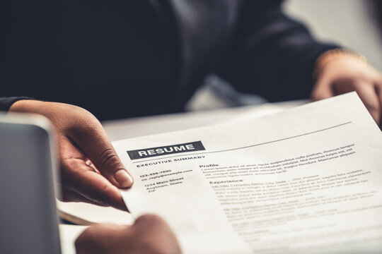 Close up view of employee candidate hands CV resume document to the interviewer HR human resources department manager at the interview room. Job application, recruit and labor hiring concept.