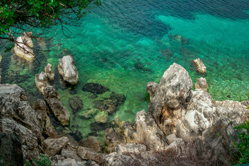 Beautiful landscape with sea bay with turquoise water, rocks and cliffs, green trees and bushes. Corfu Island, Greece.