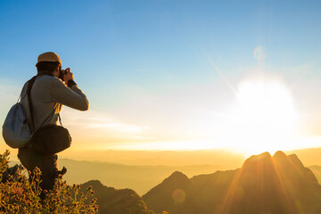 Photographer stand on the top of the mountain and shooting a photo on the top peak of mountain...