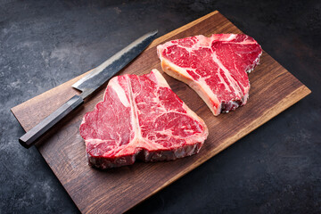 Zwei rohe dry aged Wagyu Porterhouse Steaks vom Rind angeboten als close-up auf einem Modern Design...
