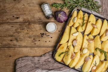 Spiced pieces of raw potato prepared to bake on old table