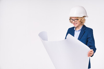 Small cute caucasian kid in hardhat holding architectural plans isolated over white background