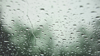 Drops on glass in rainy day. Texture of raindrops, wet glass. heavy rain, bad weather, loneliness, isolation. The texture of the wet surface, background, beautiful wallpaper.