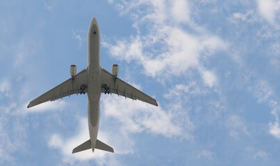 The plane goes on a background of blue and cloudy sky.
