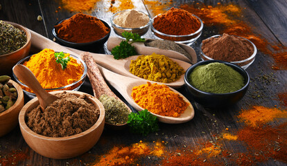 Variety of spices on wooden kitchen table.