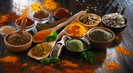 Variety of spices on wooden kitchen table.