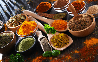 Variety of spices on wooden kitchen table.
