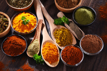 Variety of spices on wooden kitchen table.