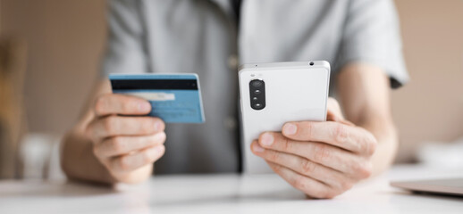 Paying online. Man holding credit card and using smartphone, businessman working in office, e-commerce, internet banking, spending money, working from home concept