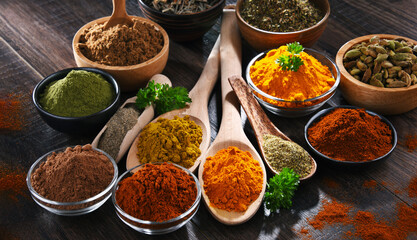 Variety of spices on wooden kitchen table.