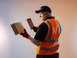 Warehouse manager in an orange vest. Warehouse manager at fulfillment center. Warehouse worker with...