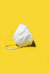 White medicine respirator KN95 mask over yellow