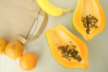 papaya, orange, banana with a paper bag in a kitchen workplace 