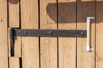 Old black hinge with ancient nails. Old brown wood planks