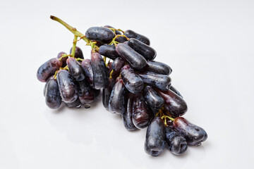 a bunch of black grapes ladies fingers on a white background