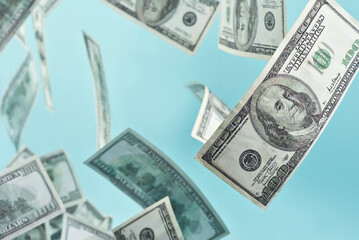 Green dollar bills on a blue background. 100 dollar bills close up. The concept of wealth and success. Money flies in the air.