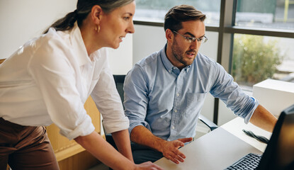 Office workers working together on computer