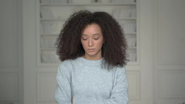 Young american black woman in blue warm sweater with curly hair, middle shot. Afro hairstyle, attractive beautiful woman on white blurred background