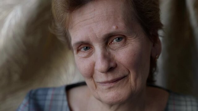 charming granny is smiling and looking at camera friendly, portrait of old pretty woman indoors
