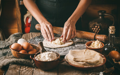 Woman hands cooking bread with cheese, eggs and herb on rustic wooden background. Homemade healthy...