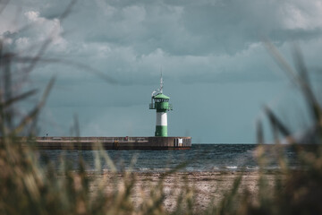 behind the dunes is a lighthouse of Travemuende