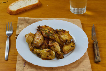 Garlic Chicken Wings (Pollo al ajillo). Delicious Spanish Tapa dish served with crusty bread, silver curtlery and a glass of water