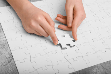 Hands assemble the puzzle on the table