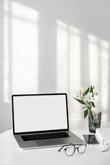 	
Laptop computer with empty blank mockup screen over white modern living room design. Work place,...