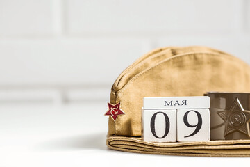 The holiday is May 9. St. George ribbon, military cap, wooden calendar on a white background. The...