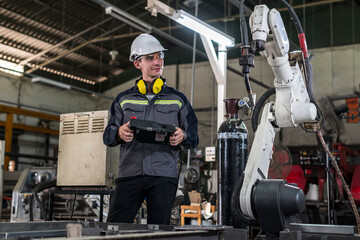 Robotics control engineers solve problems and setting programming of control panel for industrial robot arm controller in production plant factory