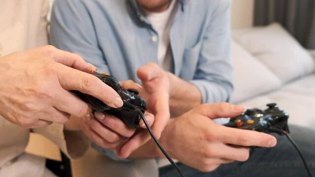 Senior handicapped woman play videogames with son